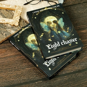 Hardcover Light Chaser fairy notebook with silver foil lettering on black cover and moon art