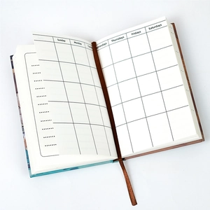 Detailansicht eines offenen Monatsplaners mit Gitterlayout, Lesezeichen und blauem Cover