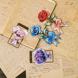 Vintage metal flower bookmarks in various colors on antique paper background