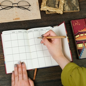 Détail du carnet rouge avec mise en page hebdomadaire et pages en papier crème protecteur