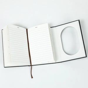 Macro shot of lined inner pages with a brown ribbon bookmark and oval window cover