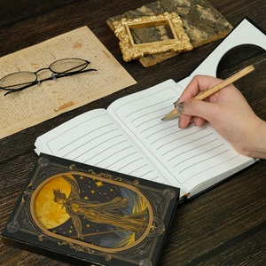 Detail of vintage moon magic wand notebook with gold foil design on wood desk