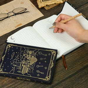 Taccuino A5 a tema magico blu navy con castello dorato su scrivania in legno vintage