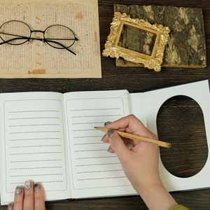 Macro detail of vintage style black notebook with dotted lines on dark wooden desk