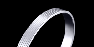 Macro shot of silver magnetic therapy bracelet with precise parallel groove textures