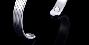Macro detail of silver magnetic therapy bracelet featuring vertical striped texture design