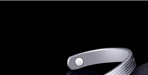 Close-up of silver magnetic therapy cuff bracelet with polished horizontal grooves
