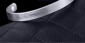 Detail view of silver magnetic therapy bracelet with vertical stripes on textured leather