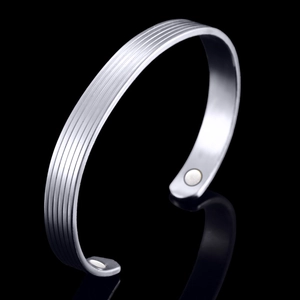 Silver plated magnetic therapy cuff bracelet with vertical line patterns on black background