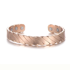 Dettaglio del bracciale magnetico in oro rosa con design intrecciato ed elegante