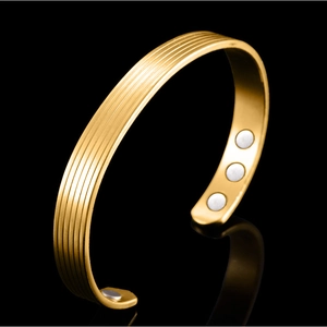 Goldenes Kupferarmband mit Magnettherapie, vertikalen Streifen und sechs Magneten auf Schwarz