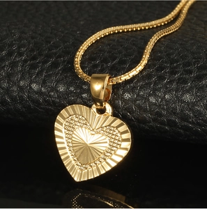 Close-up of 18K gold plated heart pendant with radiant texture and box chain detail