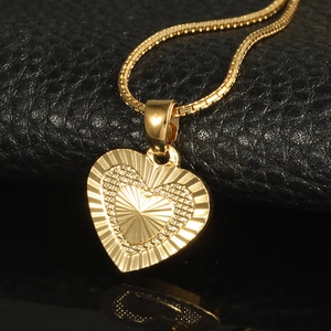 Fashion 18K gold plated heart pendant necklace with sunburst texture on black background