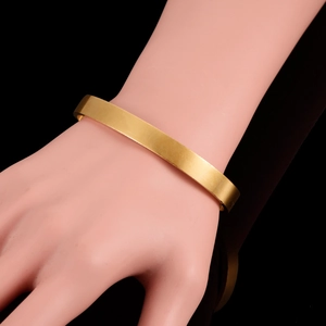 Minimalist 18K gold plated open cuff bracelet with matte finish on female wrist