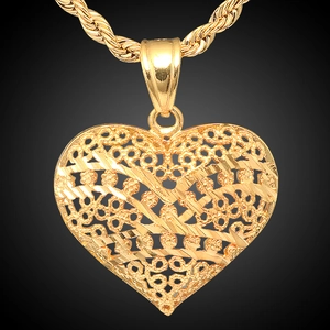 Macro shot of 18K gold plated heart pendant with filigree hollow texture and rope chain