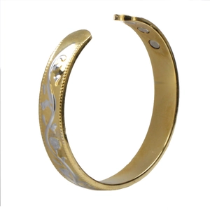 Detail of gold-plated magnetic cuff bracelet with silver floral relief and inner magnets
