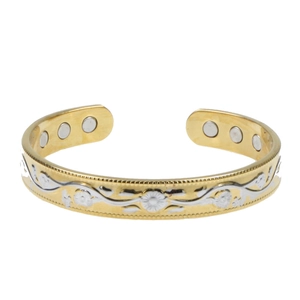 Detail of gold magnetic therapy cuff with silver floral engraving and interior magnets