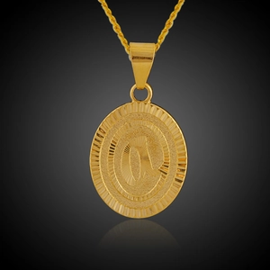 Dettaglio di un ciondolo ovale placcato oro 18K con lettera incisa e texture