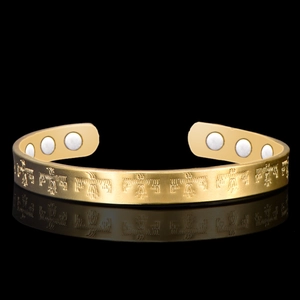 Detail of gold magnetic therapy bracelet featuring tribal eagle patterns and magnets