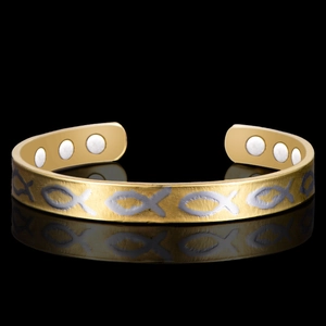 Macro detail of 18K gold-plated magnetic therapy cuff with silver Ichthys fish patterns