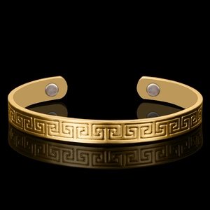 Classic 18K gold plated magnetic therapy bangle with Greek key pattern on black surface