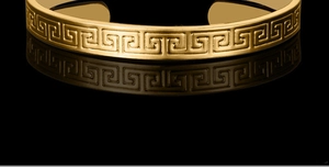 Macro shot of 18K gold plated cuff bracelet with classic Greek key pattern carving