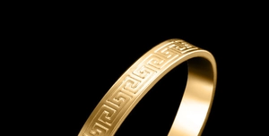 Macro shot of 18K gold plated bracelet featuring classic meander Greek key engraving