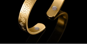 Macro shot of 18K gold plated magnetic bracelet with Greek key pattern and magnets