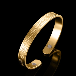 Classic 18K gold plated magnetic therapy bangle with Greek key pattern on black background