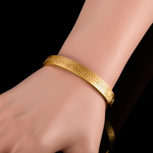 Classic 18K gold plated bangle with Greek meander pattern shown on wrist
