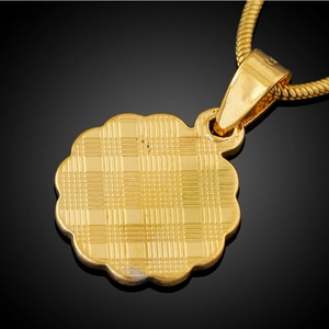 Macro view of 18K gold plated round pendant with scalloped edges and checkered back texture