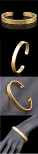 Dettaglio del bracciale magnetico a forma di C placcato oro 18K con finitura testurizzata