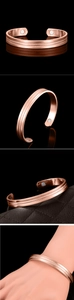 Detail of rose gold magnetic therapy bracelet featuring textured diamond pattern and open cuff
