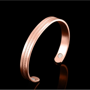 Rose gold magnetic therapy cuff bracelet with textured grid surface and silver magnets