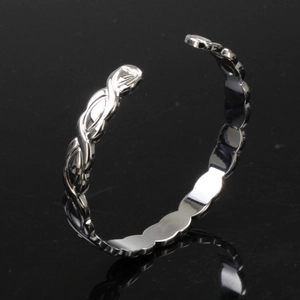 Detalle de la pulsera magnética plateada con nudo entrelazado pulido y diseño ondulado