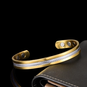 Adjustable magnetic therapy bracelet with two-tone gold and silver pattern on black leather