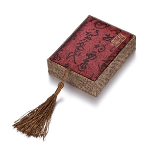 Detail of red brocade gift box with black calligraphy and elegant brown woven texture