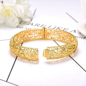 Detailansicht eines 24K vergoldeten Armreifs mit filigranem Blumenmuster und Klappverschluss