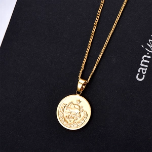 Gold coin pendant necklace with embossed lion crest and sun emblem on a black background