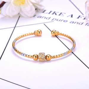 Detailed macro of two-tone twisted cable bracelet with pavé-set zircon cylinder