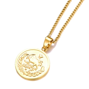 Detailed macro view of gold-plated lion and sun embossed pendant on a classic cuban chain
