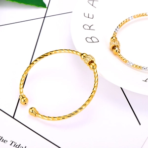 Detail of gold-plated bangle featuring checkered texture and micro-pave zircon beads