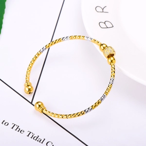 Two-tone gold and silver open bangle with diamond-cut texture and zircon bead