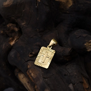 Close-up of 18K gold plated cross pendant with sunburst texture on wooden background