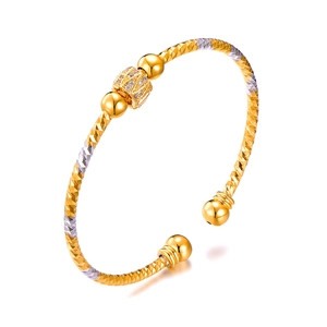 Gold and silver two-tone open bangle with diamond-set crown center and dual golden beads