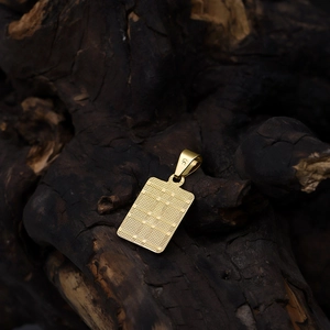 Textured 18K gold plated rectangular cross pendant on rustic dark wood background