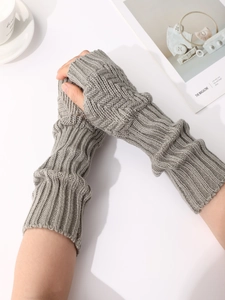 Details der grauen Zopfstrick-Struktur und fingerlosem Design der Armstulpen
