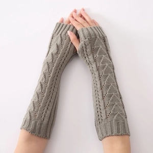 Détails de mitaines grises en maille avec motifs ajourés géométriques et trous de pouce