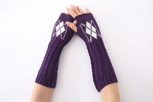 Gedetailleerde gebreide textuur van paarse armwarmers met witte ruitpatronen