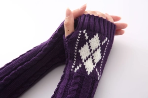 Detail van donkerpaarse gebreide armwarmers met wit ruitpatroon en geribbelde manchetten